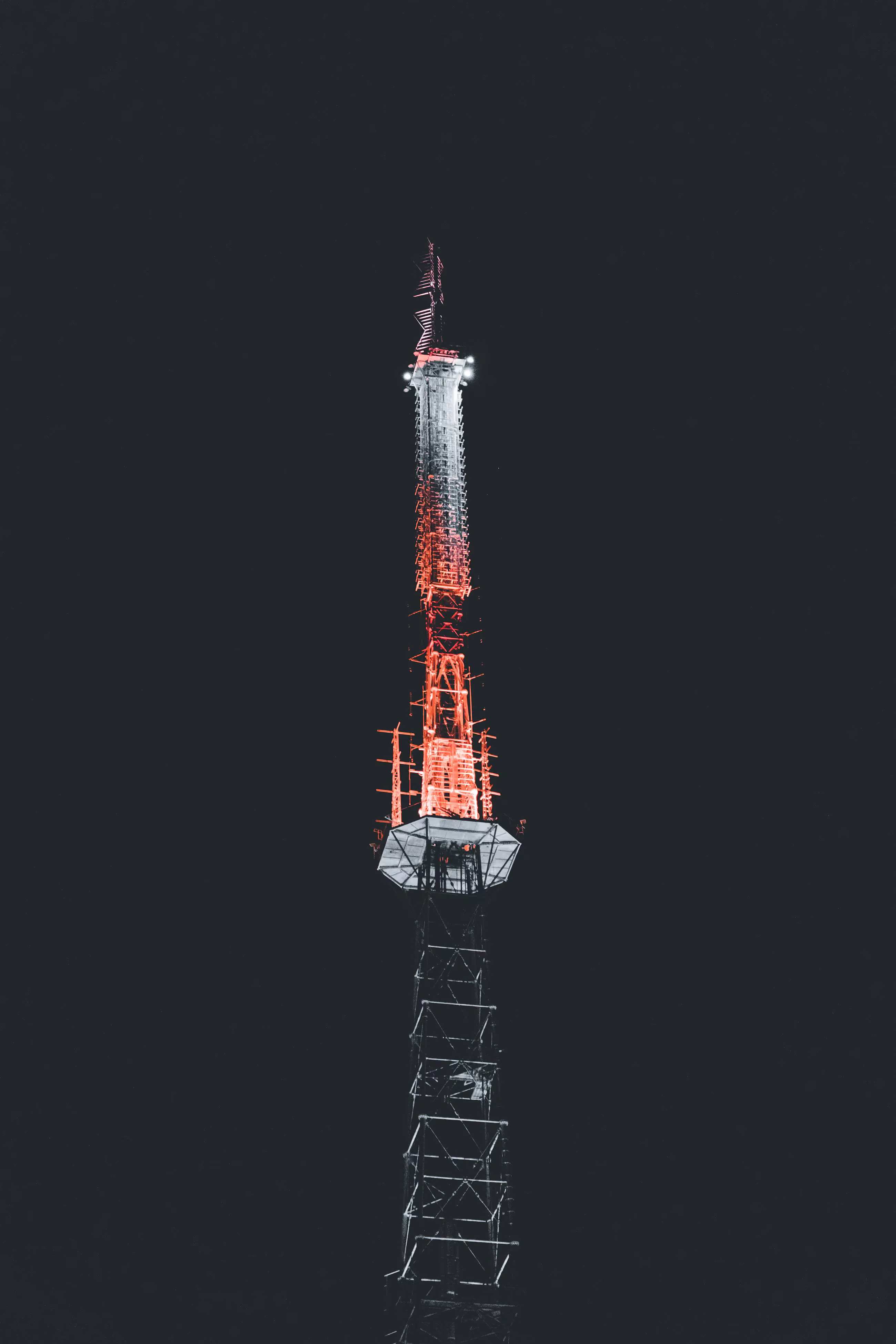 A black tower cut by a vivid red light